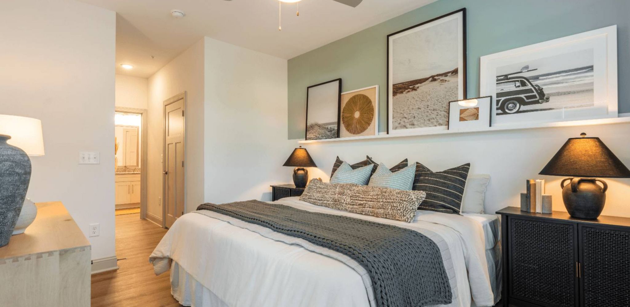 Hawthorne Waterway apartment bedroom with wood flooring, bedside tables, and bed