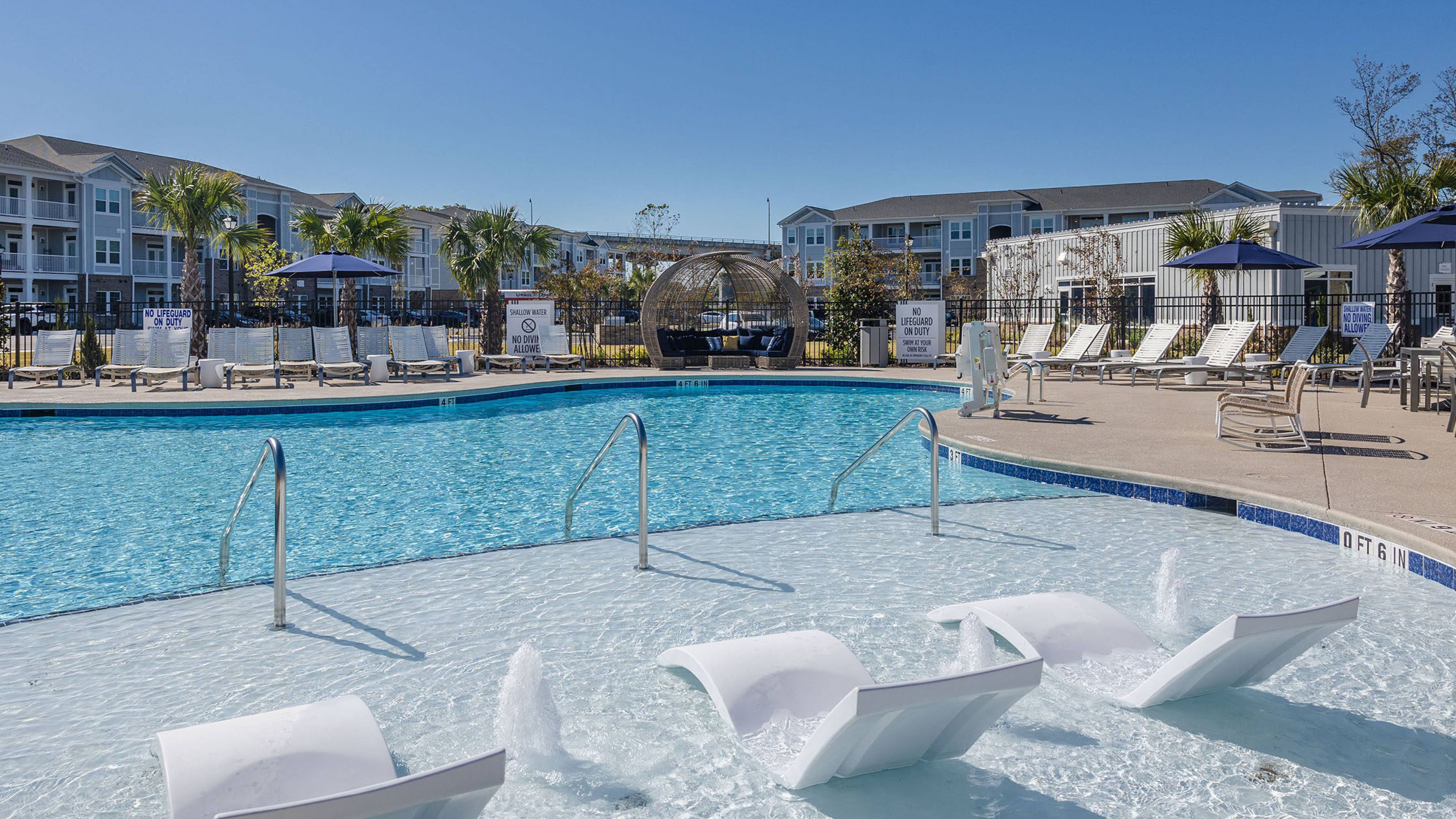 Hawhorne Waterway luxury outdoor pool with in-pool lounge chairs and surrounding seating